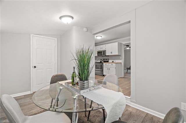 dining area featuring light wood-style flooring and baseboards