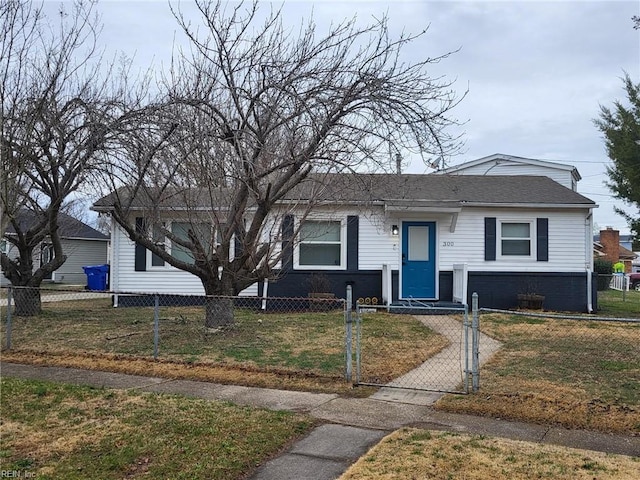 view of front of property with roof with shingles, a front lawn, and a fenced front yard