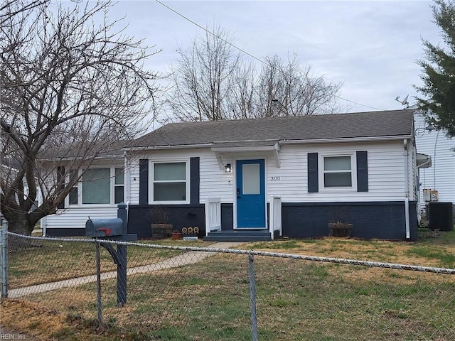 bungalow with a fenced front yard, entry steps, roof with shingles, and a front yard