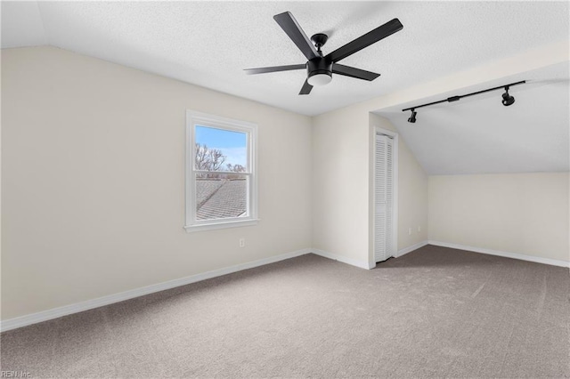 bonus room featuring baseboards, vaulted ceiling, a textured ceiling, and carpet flooring