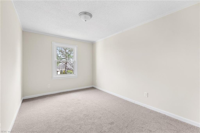 carpeted spare room featuring baseboards and a textured ceiling