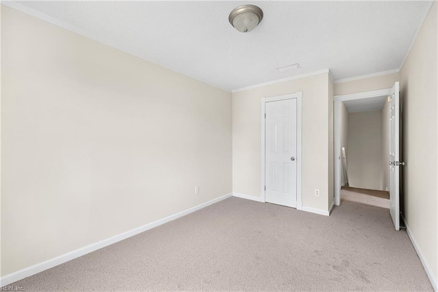 unfurnished bedroom with carpet floors, ornamental molding, and baseboards