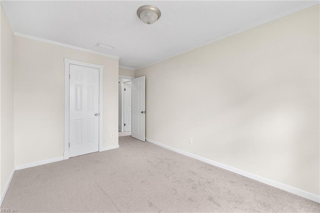 unfurnished bedroom with carpet floors, ornamental molding, and baseboards