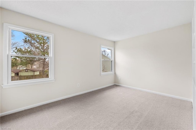 carpeted spare room featuring baseboards