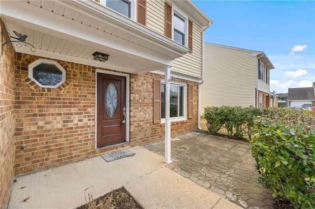 property entrance featuring brick siding