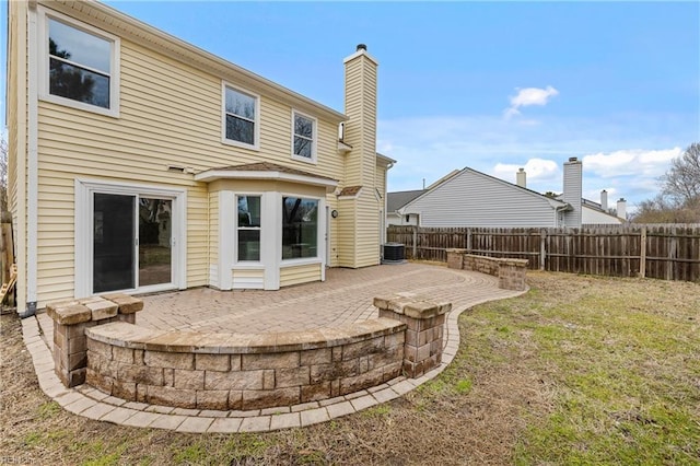 rear view of property featuring a lawn, a patio, a chimney, fence, and central air condition unit