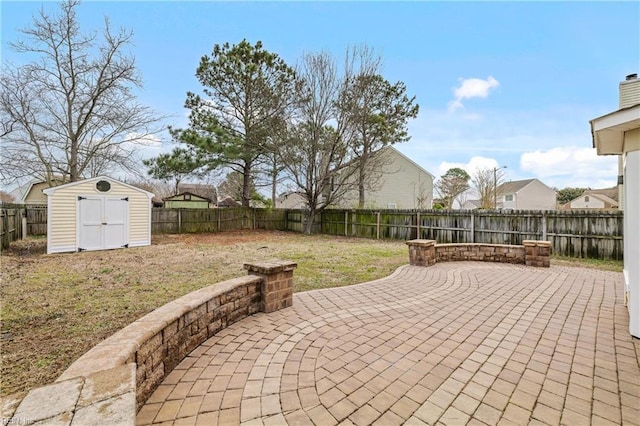 view of patio / terrace featuring an outbuilding, a storage unit, and a fenced backyard