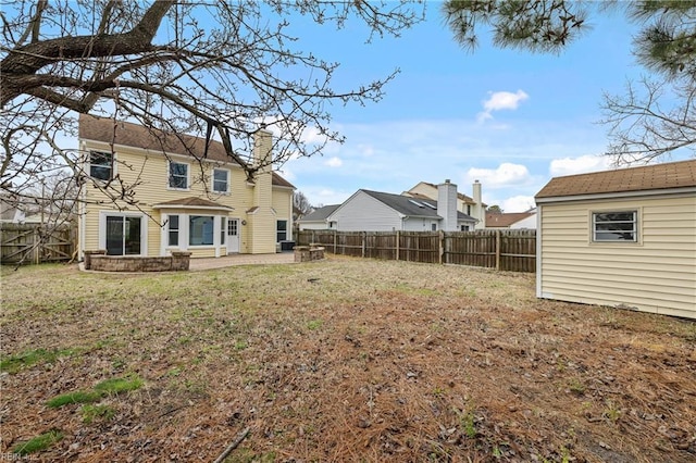 view of yard featuring an outbuilding, a patio area, and a fenced backyard