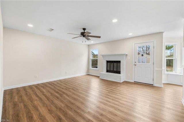 unfurnished living room featuring a fireplace, recessed lighting, visible vents, a ceiling fan, and wood finished floors