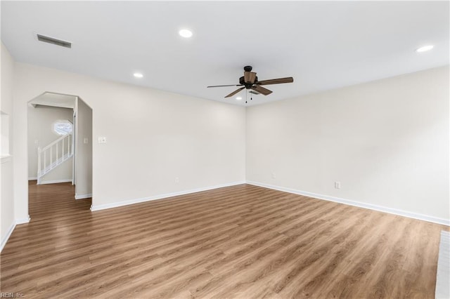 spare room featuring arched walkways, light wood-style flooring, visible vents, and recessed lighting