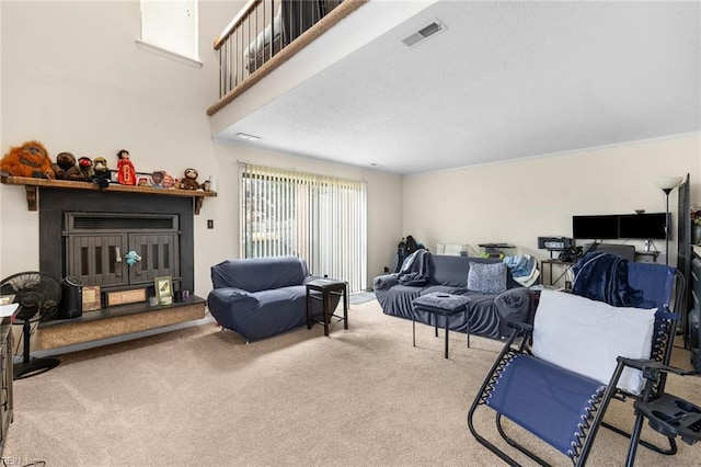 living area with carpet floors, a fireplace, and visible vents