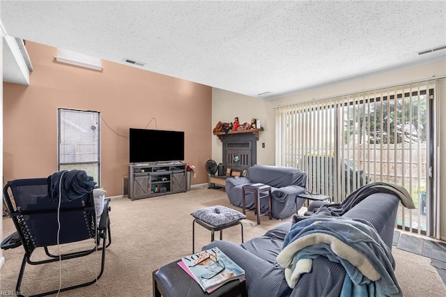 living room featuring visible vents, a textured ceiling, and carpet flooring