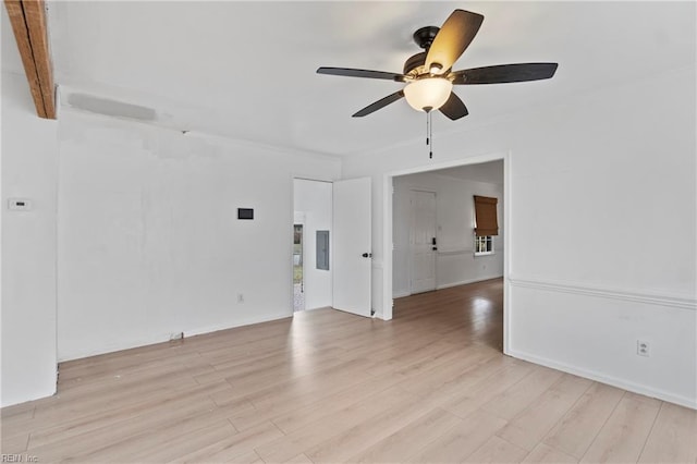 empty room with baseboards, light wood finished floors, electric panel, and a ceiling fan