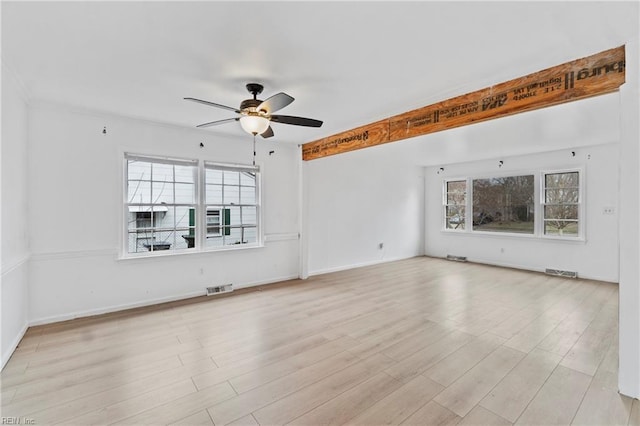 interior space with baseboards, ceiling fan, visible vents, and wood finished floors