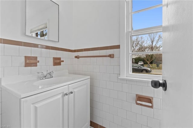 bathroom featuring a wainscoted wall, tile walls, and vanity