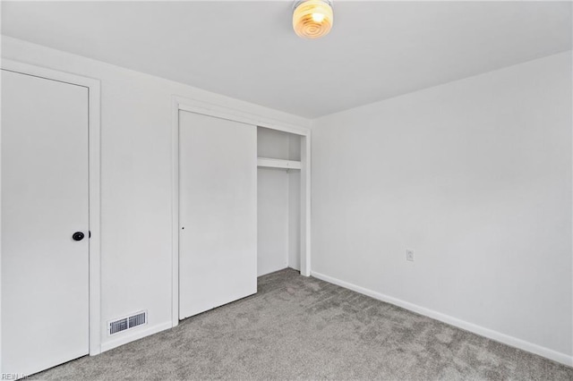 unfurnished bedroom with baseboards, carpet, visible vents, and a closet