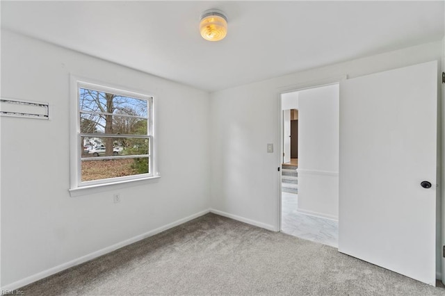 carpeted spare room featuring baseboards