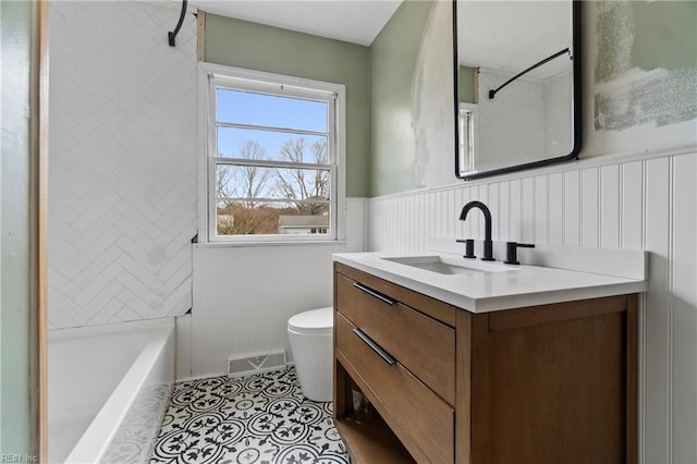 full bathroom featuring visible vents, toilet, a wainscoted wall, tile patterned flooring, and vanity