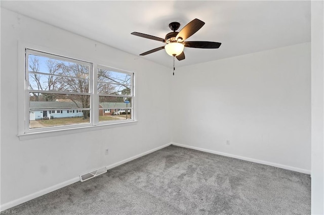 carpeted empty room with visible vents, ceiling fan, and baseboards