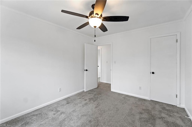 unfurnished bedroom featuring carpet, baseboards, and crown molding