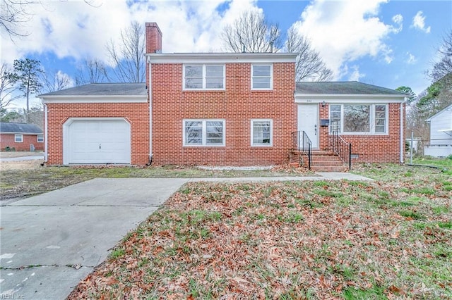 tri-level home featuring brick siding, a chimney, and an attached garage