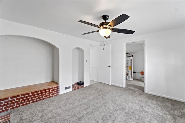 unfurnished bedroom featuring a ceiling fan, carpet, and water heater