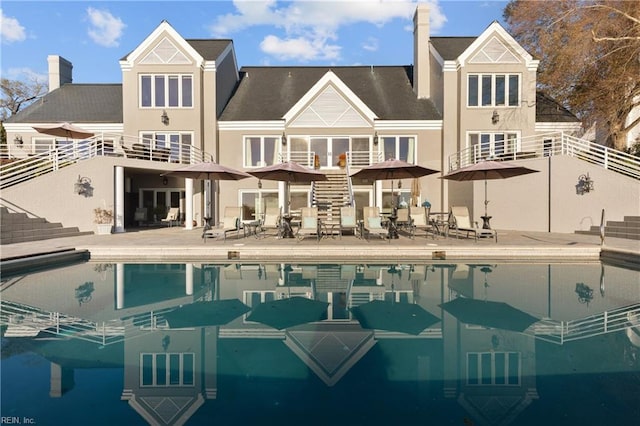 exterior space featuring a patio area, stairway, and a chimney