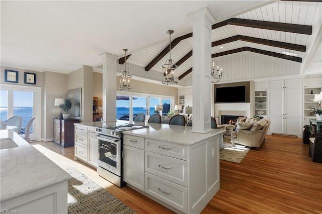 kitchen featuring vaulted ceiling with beams, stainless steel electric range oven, an inviting chandelier, open floor plan, and a lit fireplace