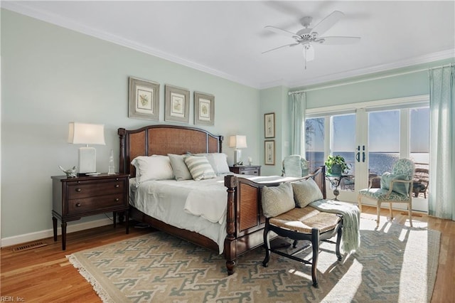 bedroom with wood finished floors, visible vents, baseboards, french doors, and crown molding