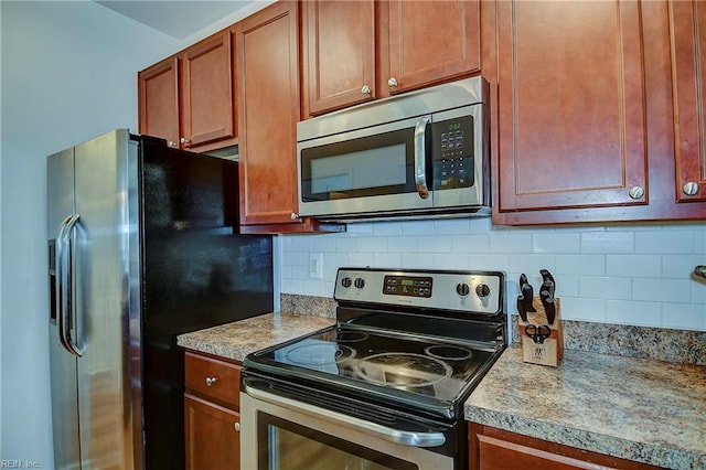 kitchen featuring stainless steel appliances, backsplash, and light countertops