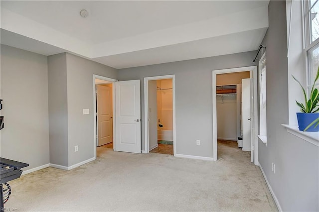 carpeted bedroom featuring connected bathroom, a spacious closet, baseboards, and a closet