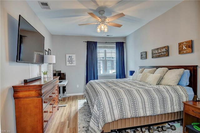 bedroom with light wood-style flooring, visible vents, and baseboards