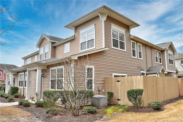 view of side of home featuring fence and cooling unit