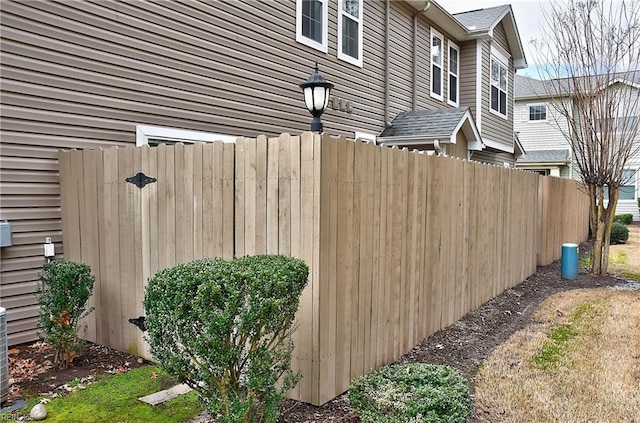 view of property exterior featuring a shingled roof and fence