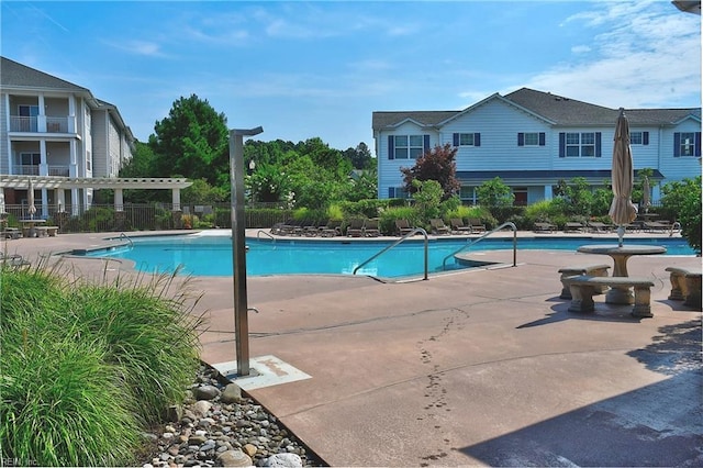 pool with fence, a pergola, and a patio