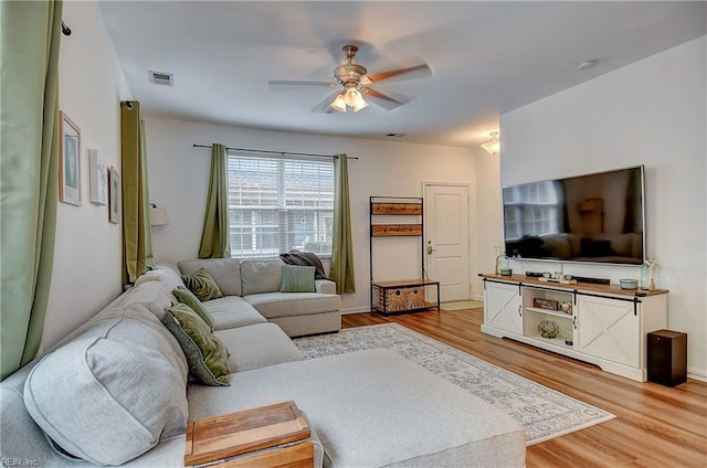 living room featuring a ceiling fan, visible vents, and wood finished floors