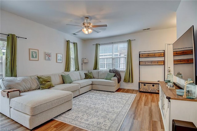 living room with a wealth of natural light, light wood-type flooring, and visible vents