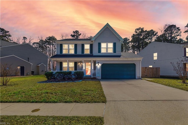 traditional home with concrete driveway, covered porch, a front yard, fence, and a garage