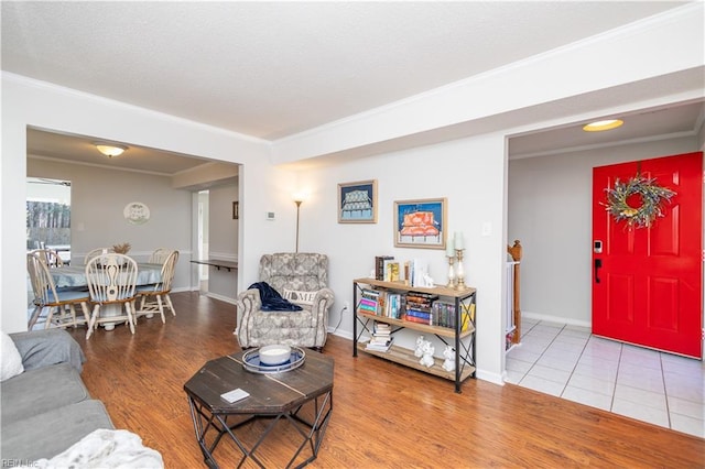 living area with crown molding, baseboards, and wood finished floors