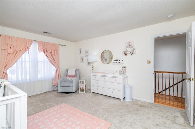 bedroom featuring a textured ceiling, carpet, visible vents, and baseboards