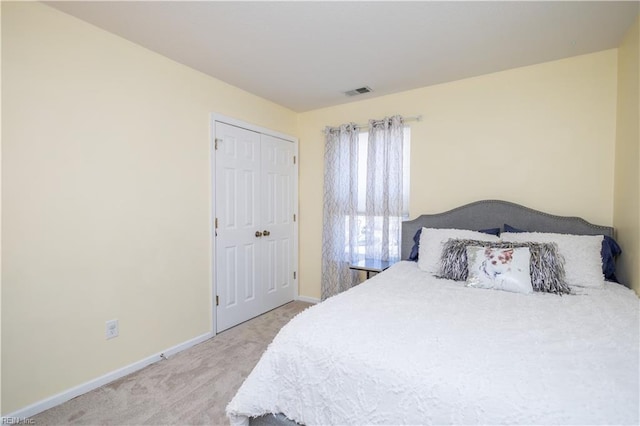 bedroom with light carpet, baseboards, visible vents, and a closet