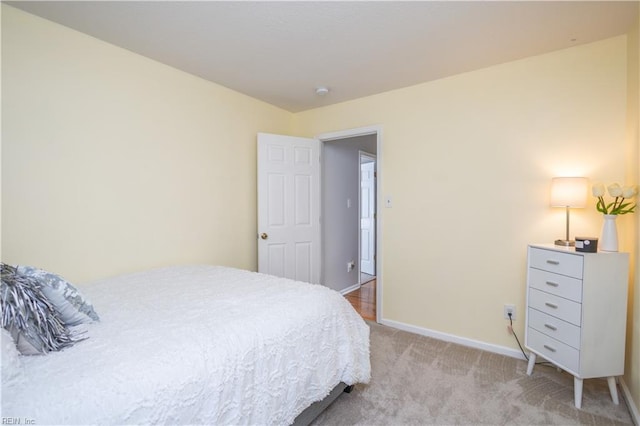 bedroom featuring light carpet and baseboards