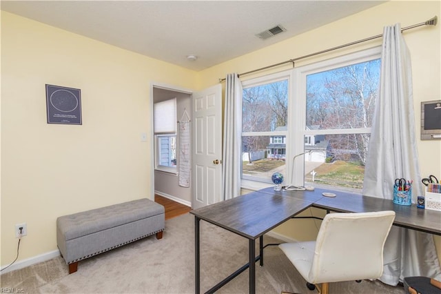 carpeted office with baseboards and visible vents