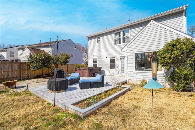 rear view of property with a patio area, a hot tub, fence, and a lawn