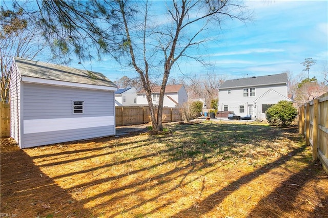 view of yard with a storage unit, an outdoor structure, and a fenced backyard