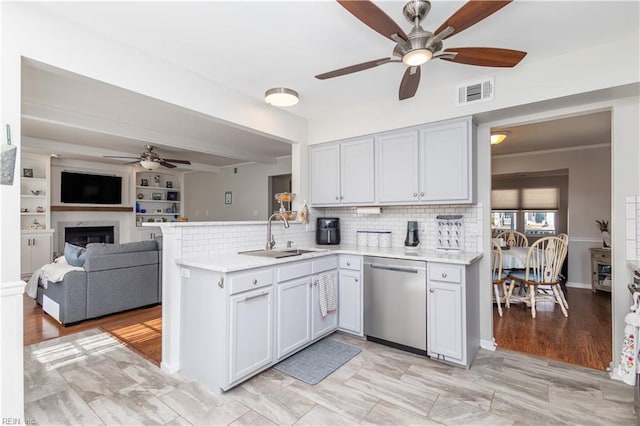 kitchen with visible vents, dishwasher, open floor plan, a peninsula, and a sink