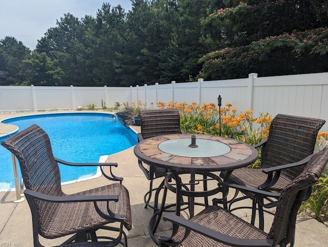 view of swimming pool with a fenced backyard, outdoor dining area, a fenced in pool, and a patio