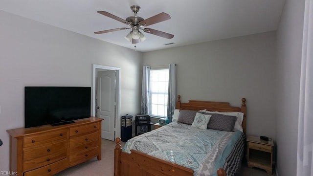 bedroom featuring a ceiling fan, visible vents, and light colored carpet