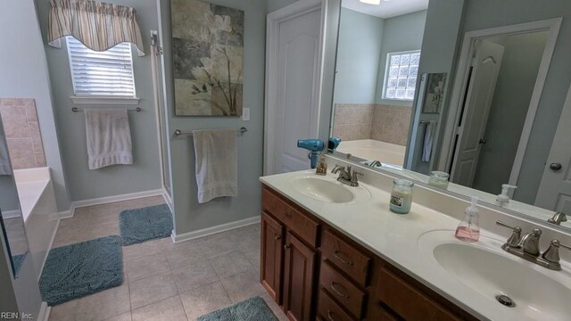 bathroom featuring tile patterned flooring, a sink, a bath, and double vanity