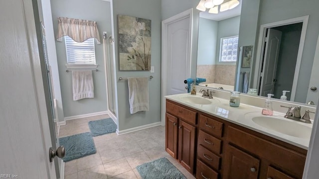 full bathroom with double vanity, tile patterned flooring, a sink, and a shower stall